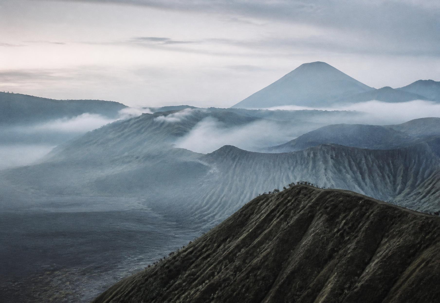Mist over volcanic highland ridges in Indonesia at first light